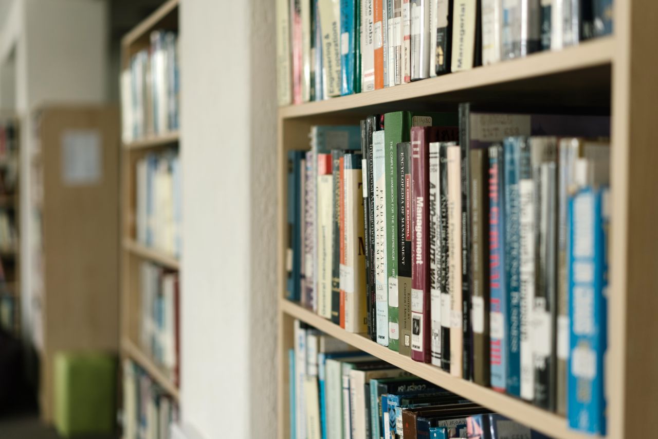 Close-up of bookshelves filled with diverse literature in a quiet library setting.